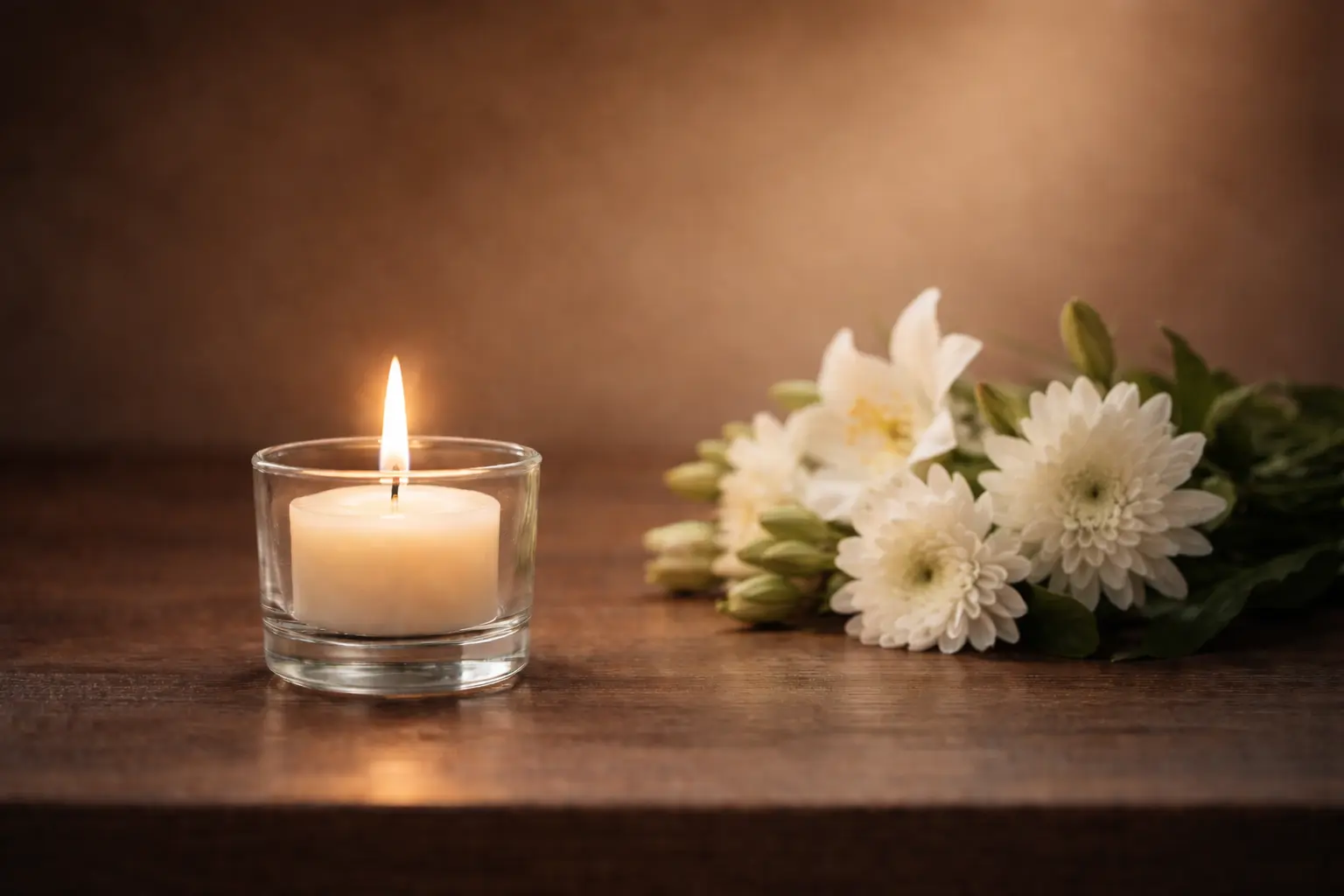 Gedenkkerze und weiße Blumen — Unterstützung und Orientierung für Angehörige nach einem Todesfall